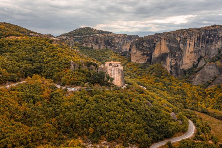 Stunning aerial view of Meteora monasteries nestled in autumnal landscape, Greece.