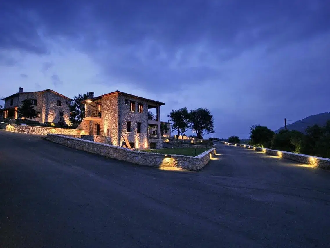 Menalia Villas & Suites stone guesthouses at dusk near Levidi, Arcadia