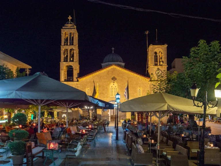 Vytina square and church lit at night